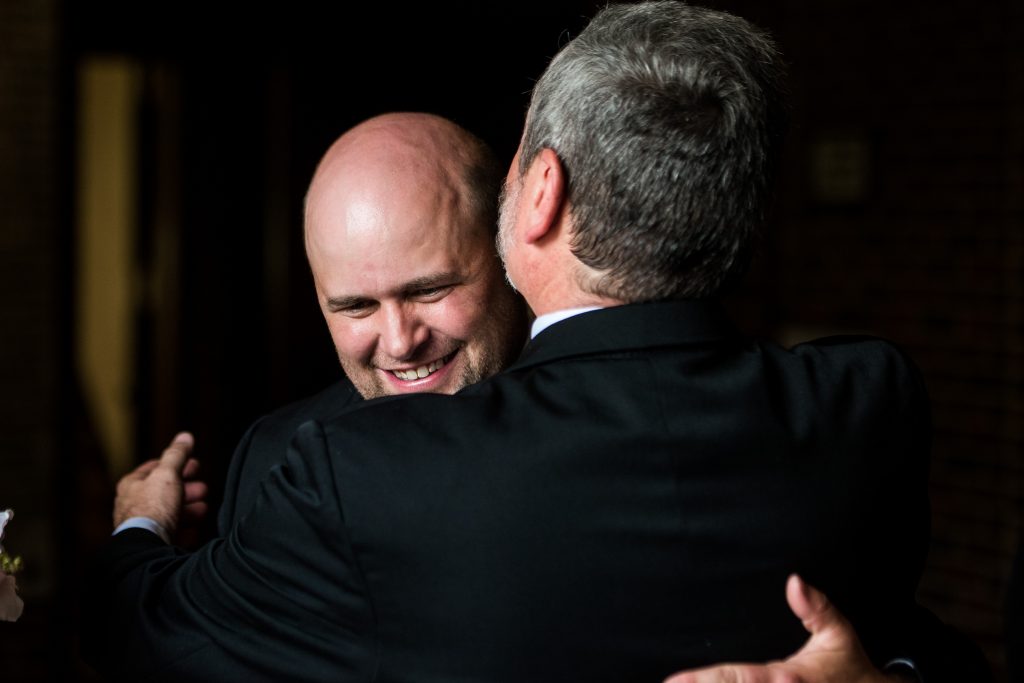 The father of the bride embracing the groom.