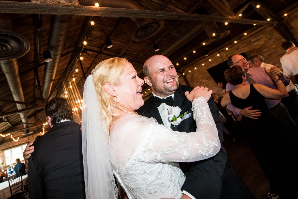 Toledo Wedding Photograph of bride and groom embracing and smiling while looking off camera